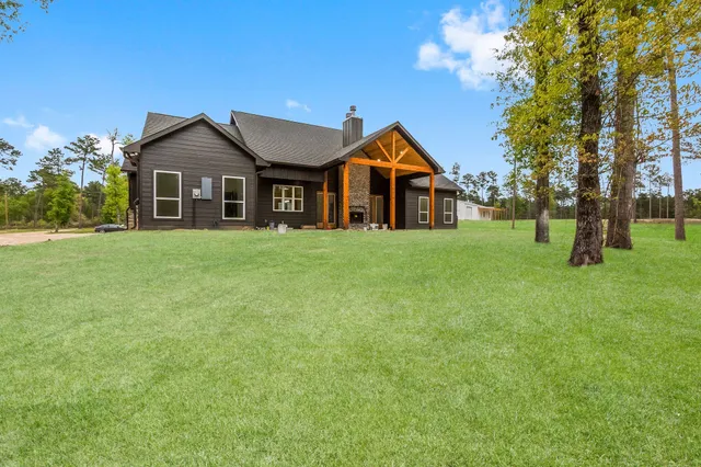 a front of a house with a yard and trees