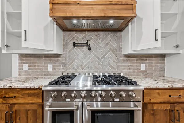 a kitchen with granite countertop a stove and a sink