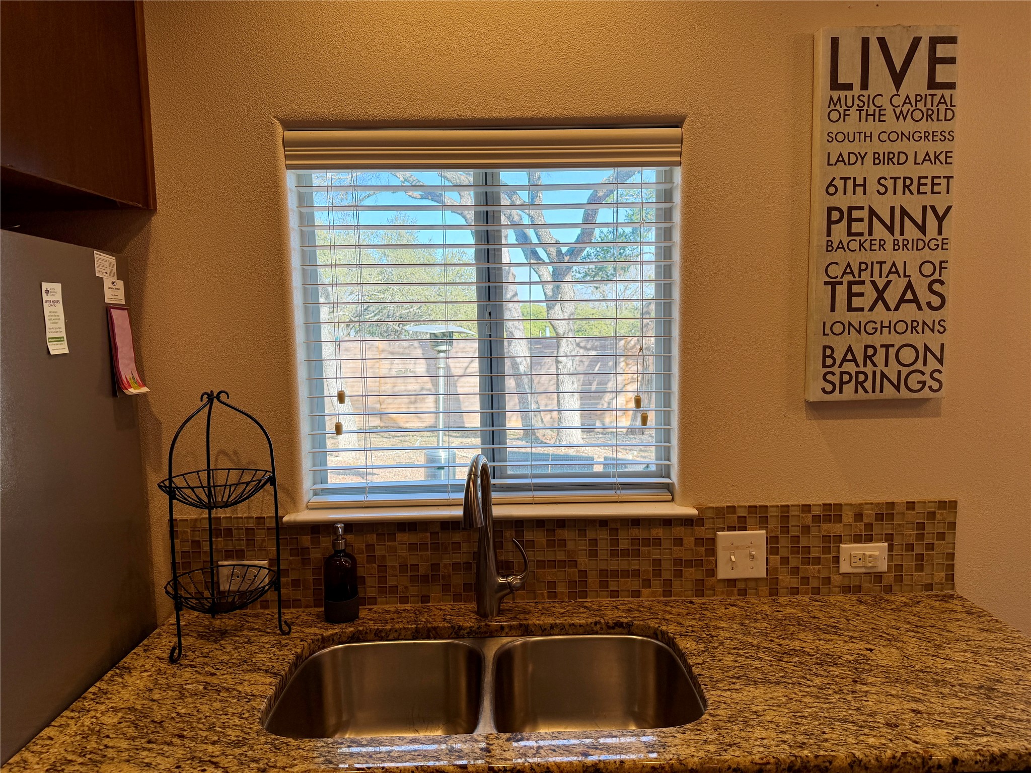 5503 Hiline Road Austin, TX 78734 - Photo 6 of 20 Kitchen with freestanding refrigerator, granite counters, tasteful backsplash, viewing window above sink