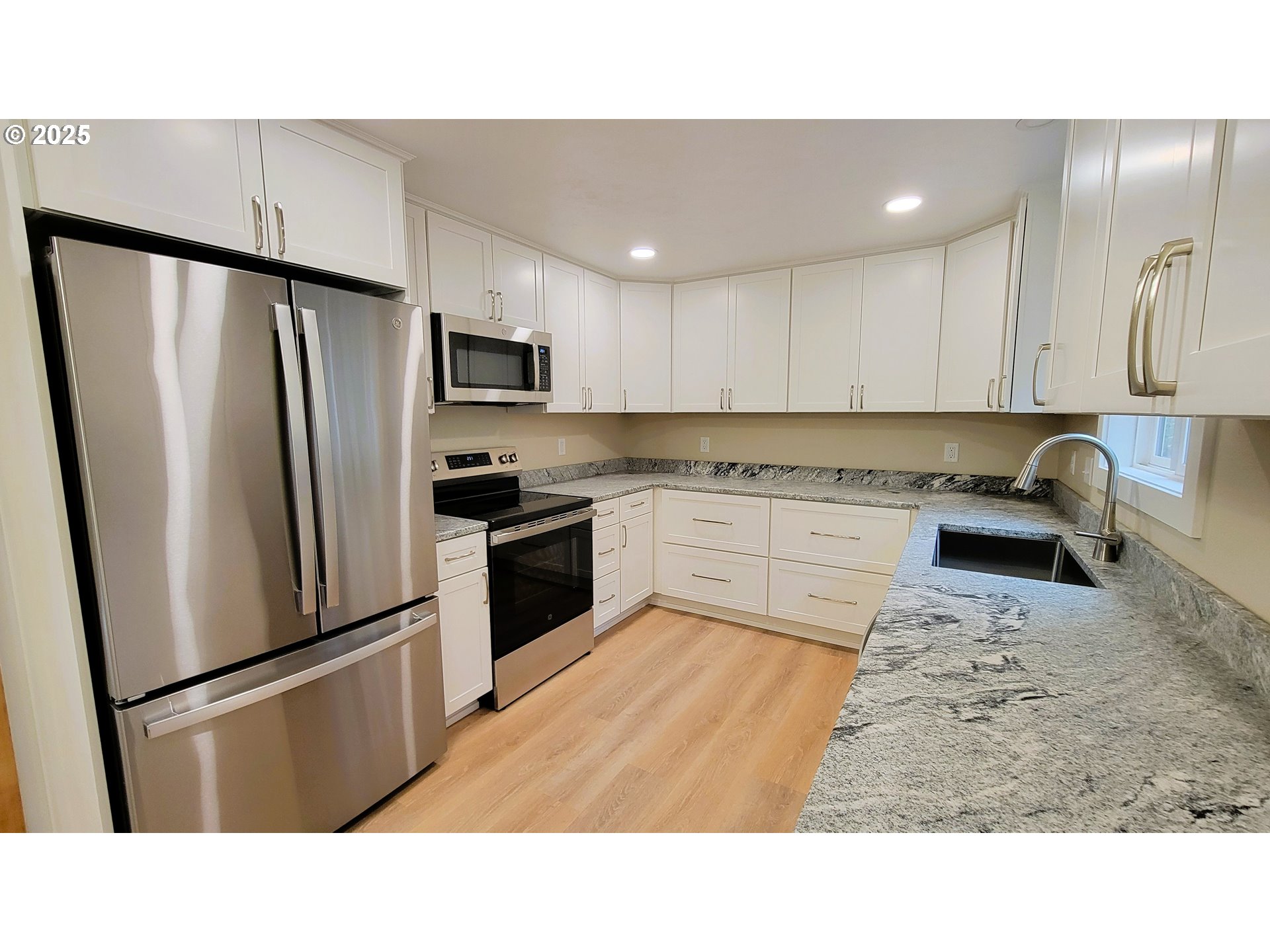 552 West D Street Springfield, OR 97477 - Photo 11 of 29 a kitchen with a refrigerator a sink and cabinets