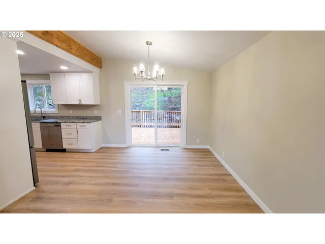 a kitchen with a refrigerator a sink and white cabinets