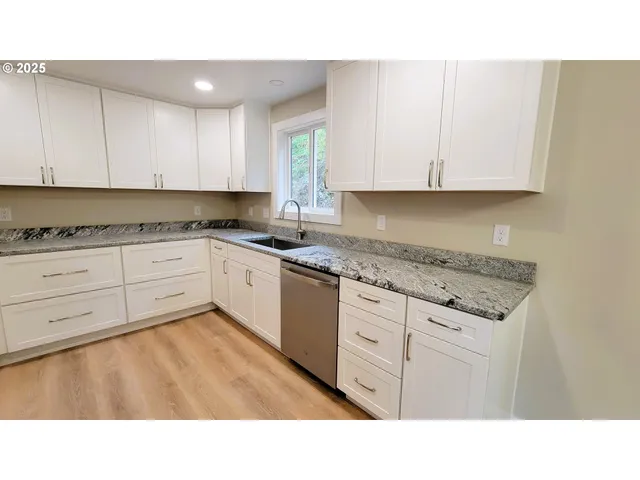 a kitchen with a refrigerator a sink and cabinets