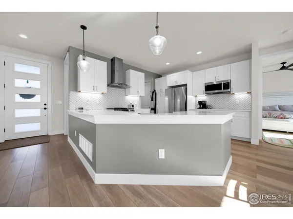 a living room with kitchen island and a wooden floor