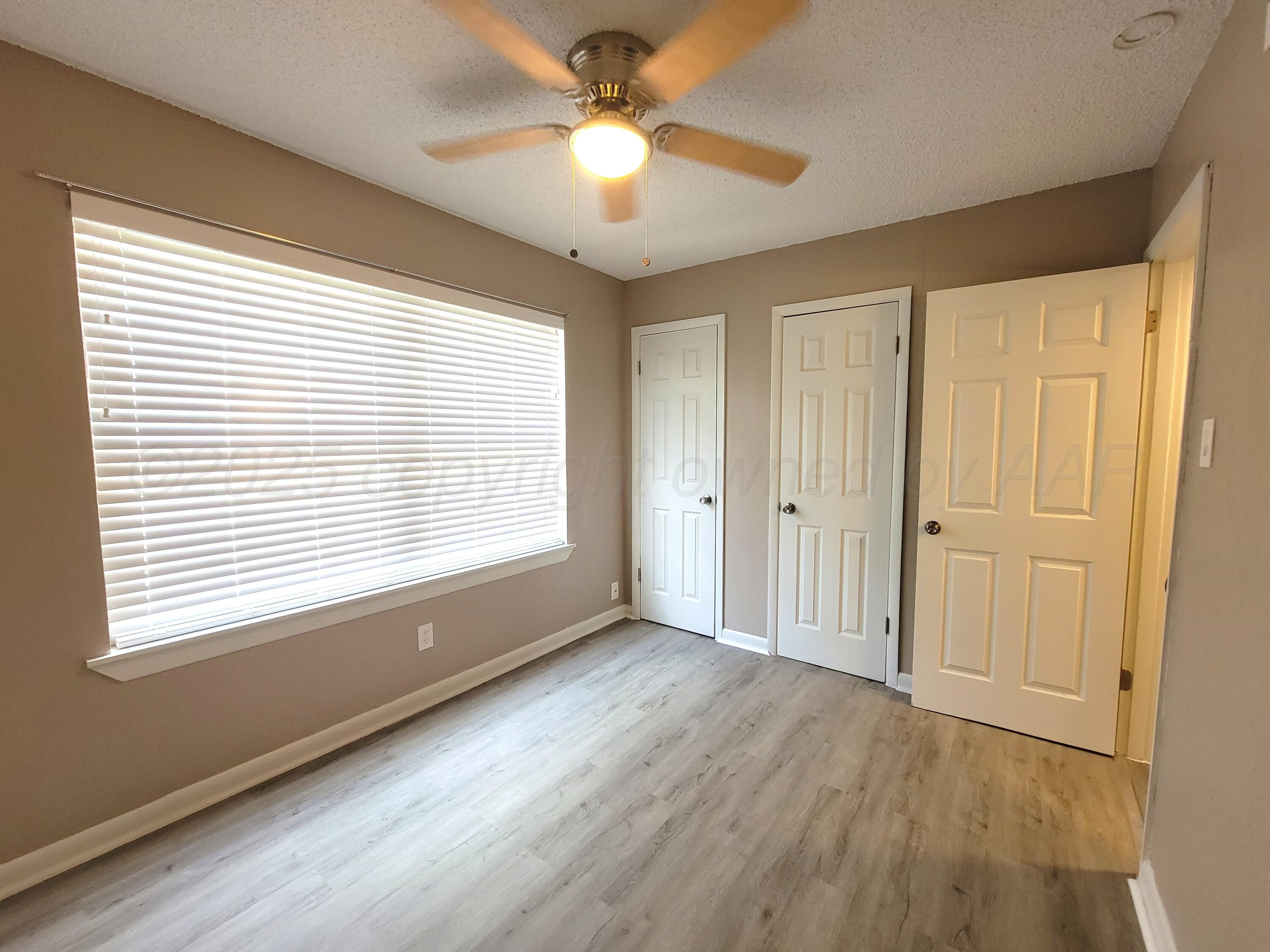 1312 Coffee Street Pampa, TX 79065 - Photo 11 of 31 a view of an empty room with a window and wooden floor