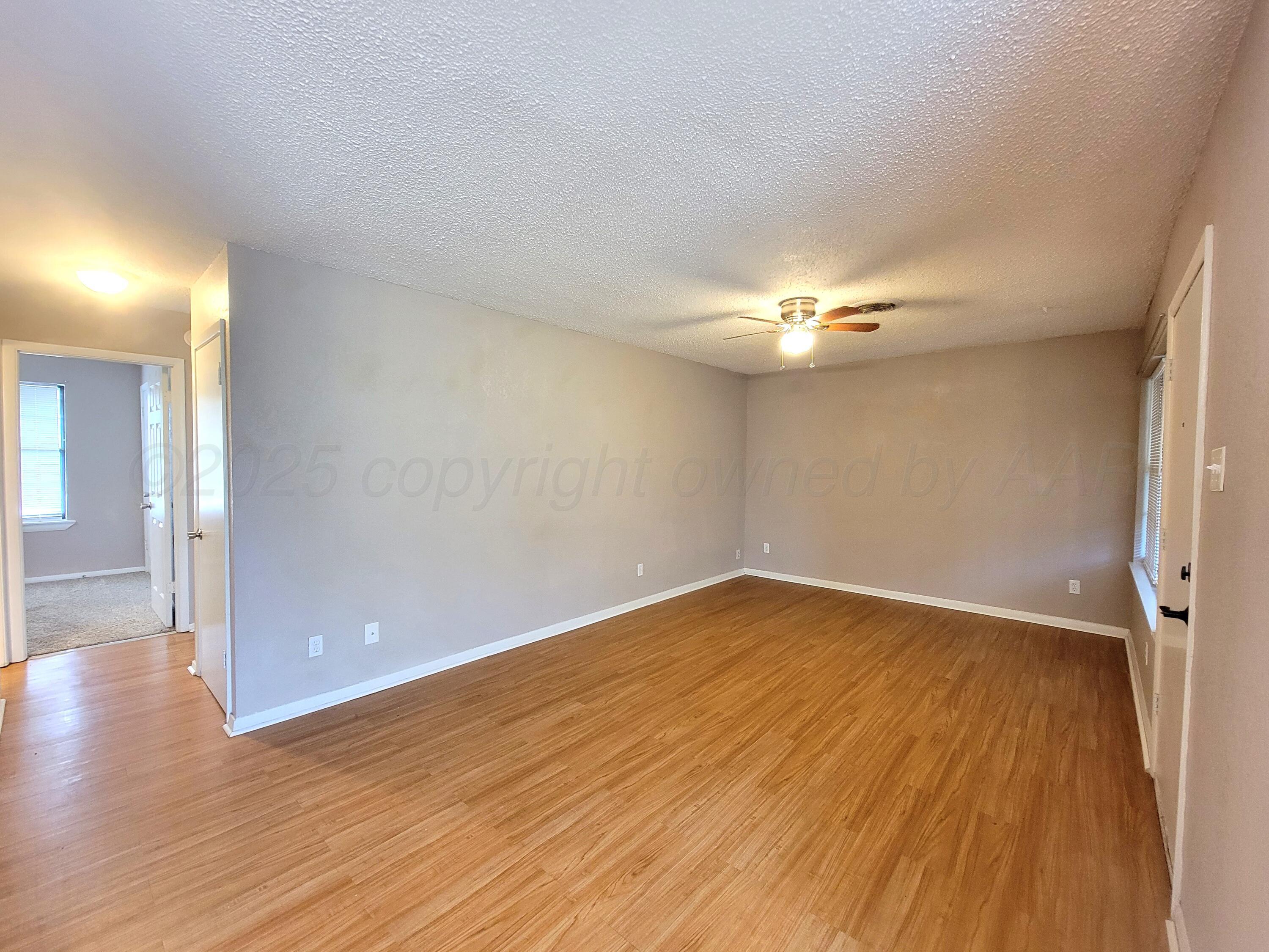 1312 Coffee Street Pampa, TX 79065 - Photo 13 of 31 a view of a room with wooden floor and chandelier