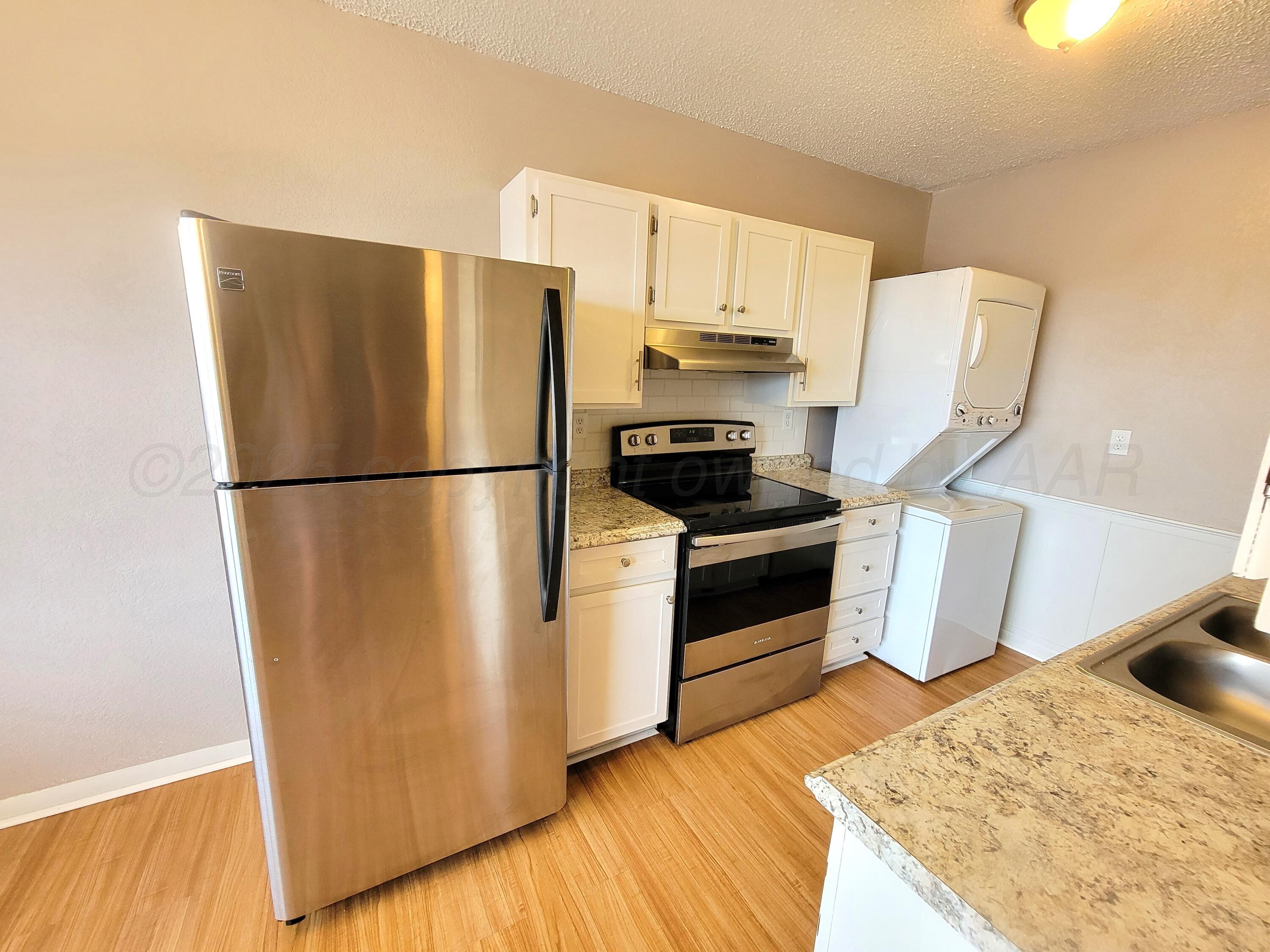 1312 Coffee Street Pampa, TX 79065 - Photo 15 of 31 a kitchen with a refrigerator a stove and wooden floor