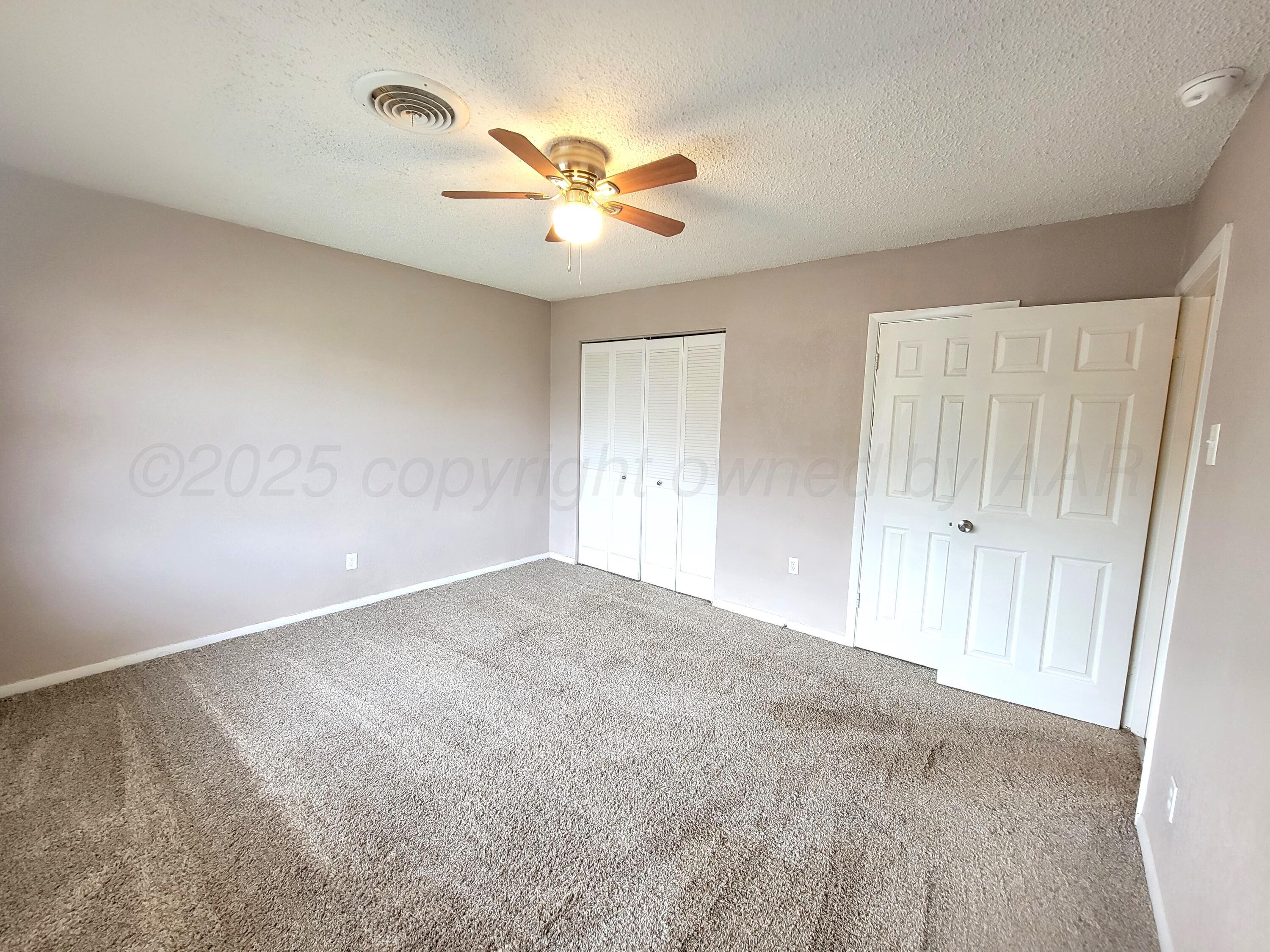 1312 Coffee Street Pampa, TX 79065 - Photo 18 of 31 an empty room with chandelier fan and windows