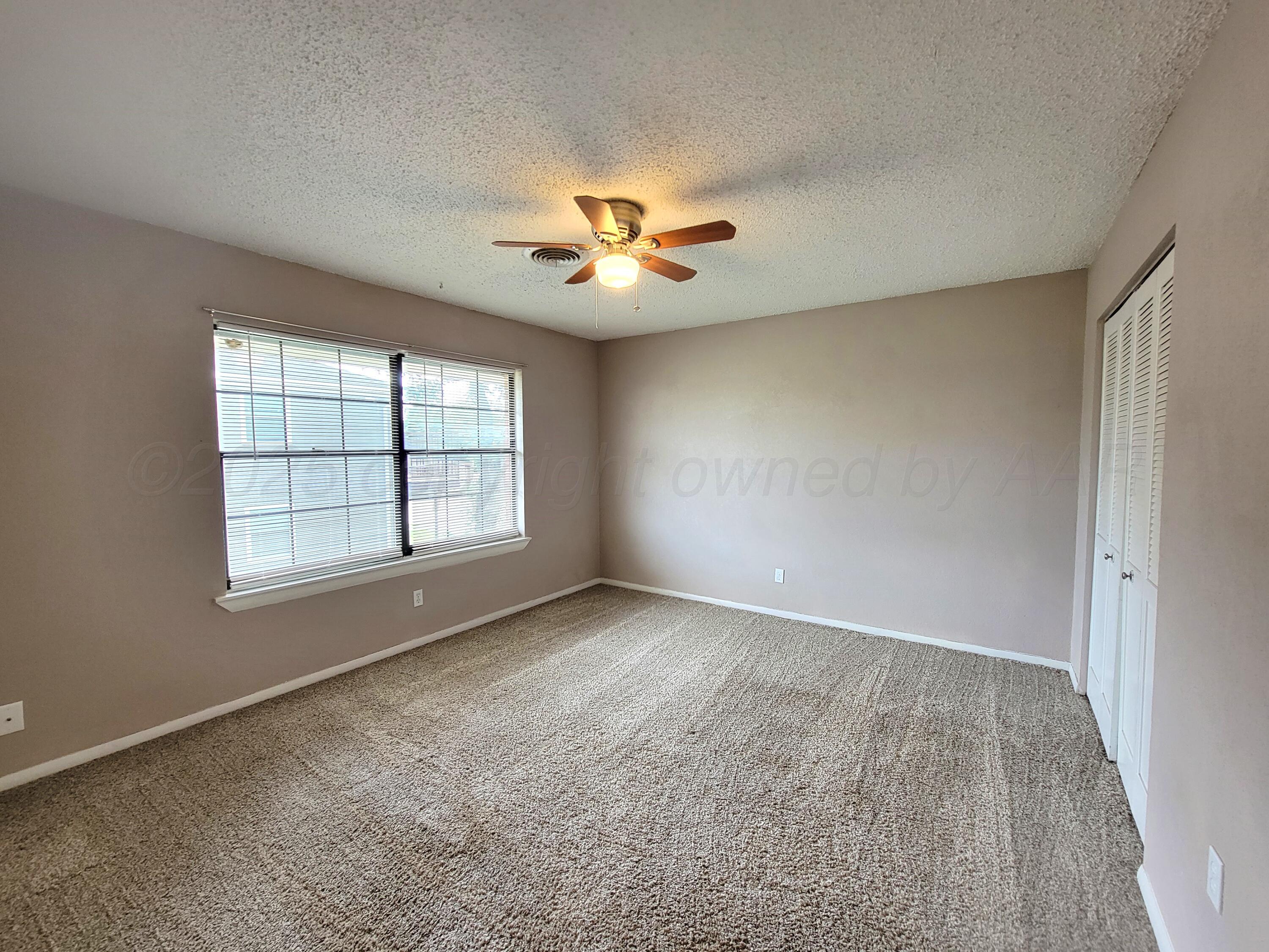 1312 Coffee Street Pampa, TX 79065 - Photo 19 of 31 an empty room with windows and ceiling fan