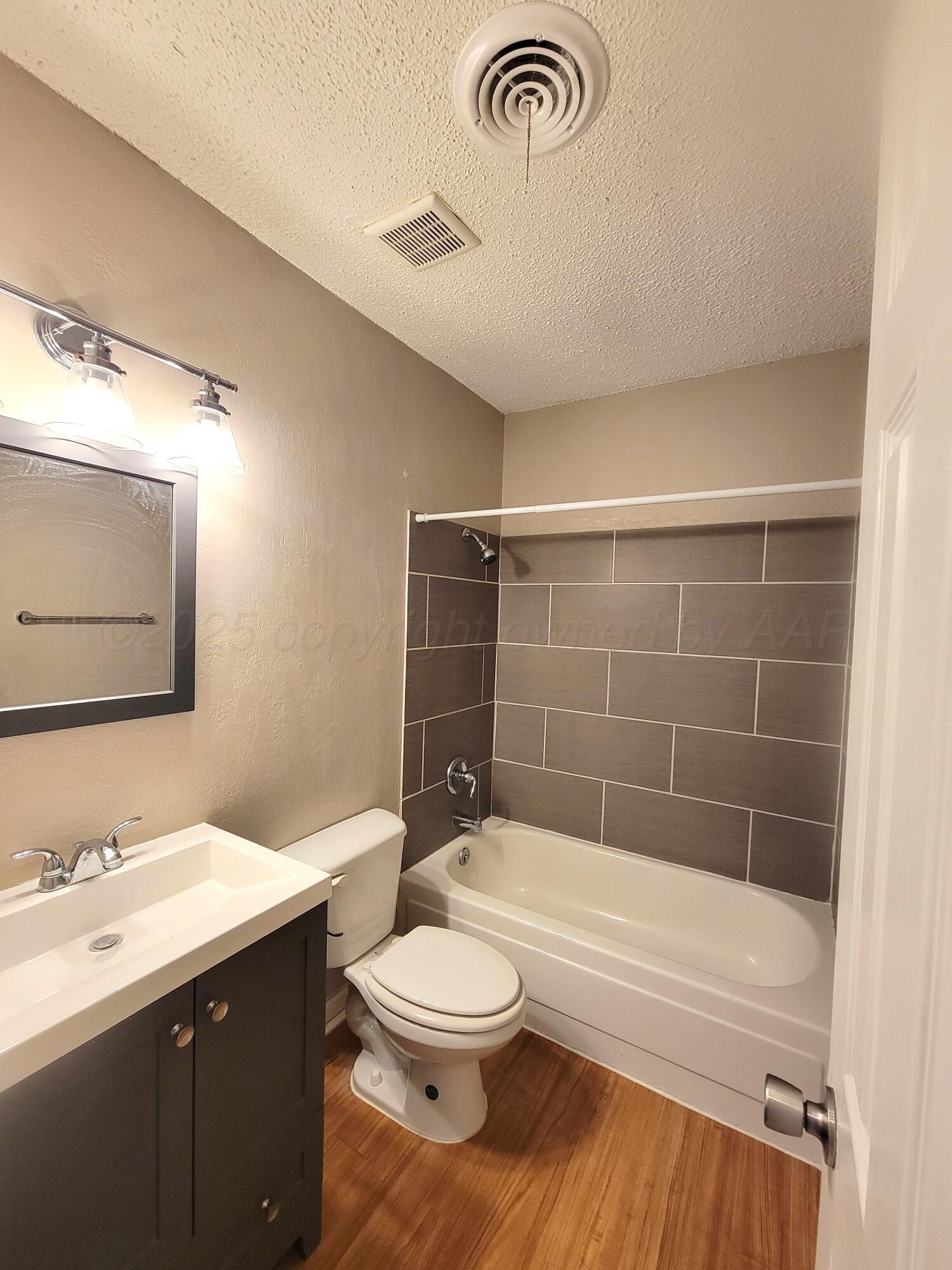 1312 Coffee Street Pampa, TX 79065 - Photo 20 of 31 a bathroom with a bathtub shower sink vanity mirror and toilet
