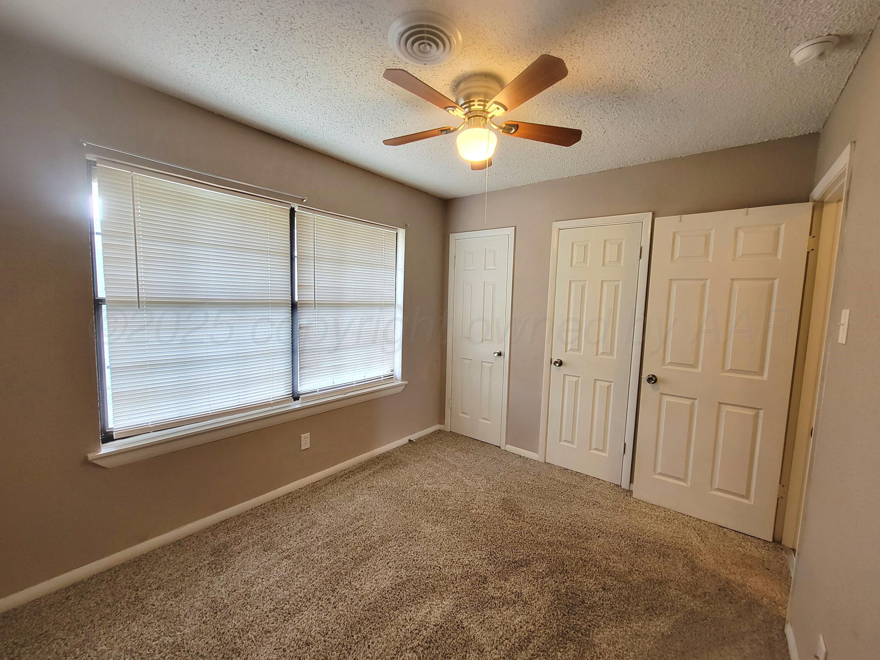 1312 Coffee Street Pampa, TX 79065 - Photo 22 of 31 an empty room with windows and fan