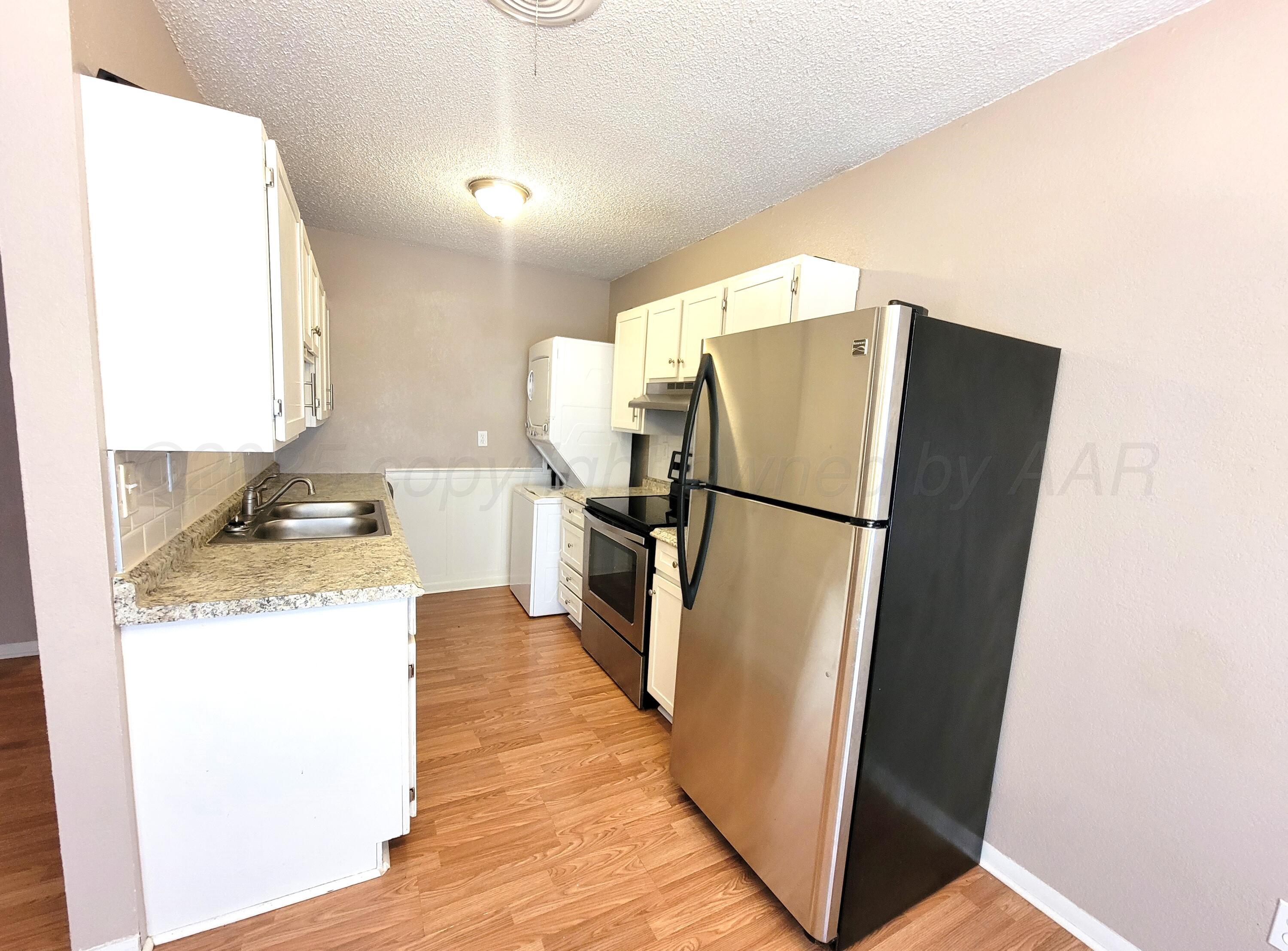 1312 Coffee Street Pampa, TX 79065 - Photo 27 of 31 a kitchen with granite countertop a refrigerator and a stove