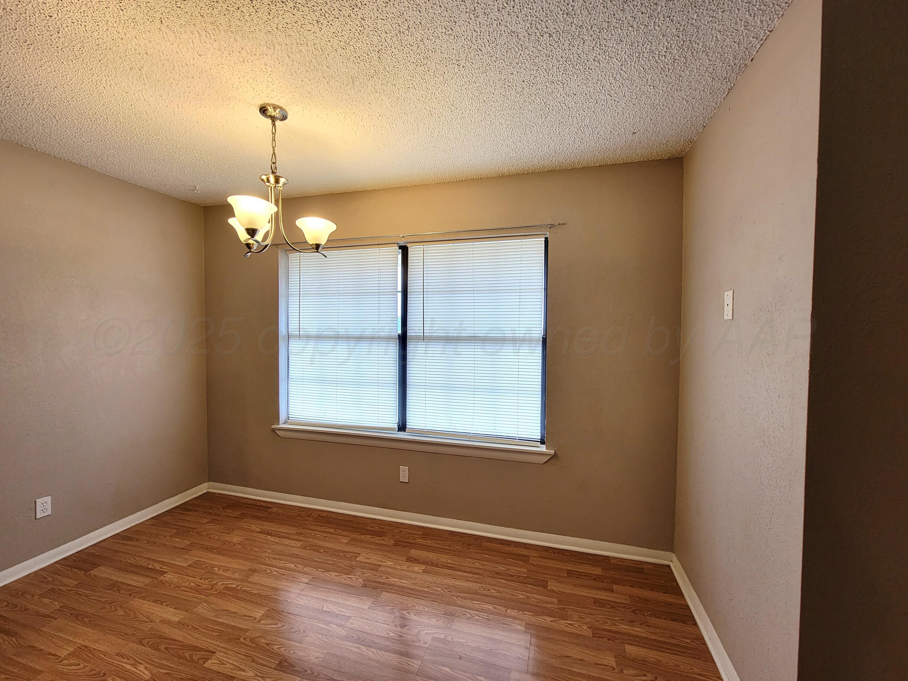 1312 Coffee Street Pampa, TX 79065 - Photo 28 of 31 an empty room with chandelier fan and windows