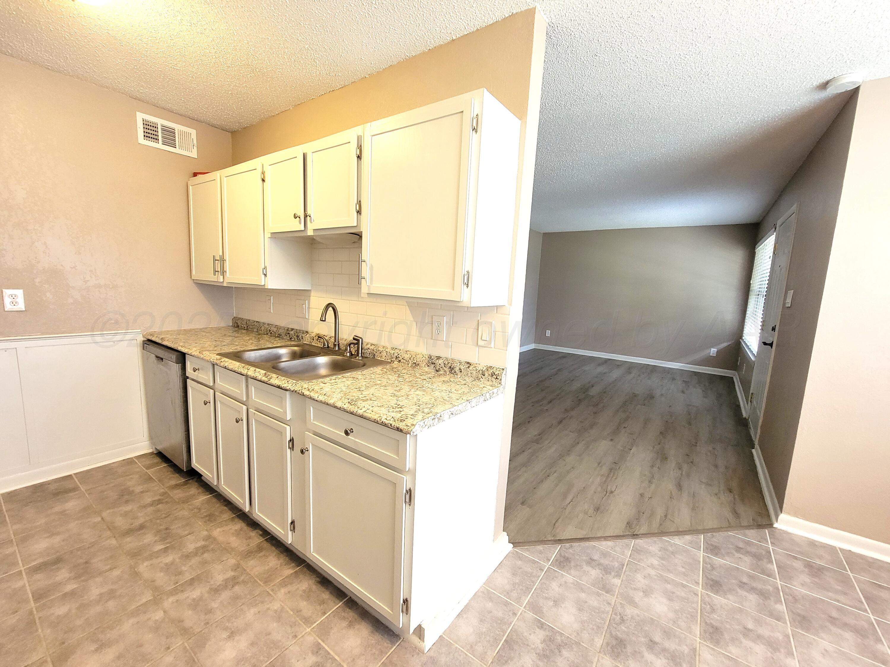 1312 Coffee Street Pampa, TX 79065 - Photo 6 of 31 a kitchen with granite countertop a sink and a stove top oven