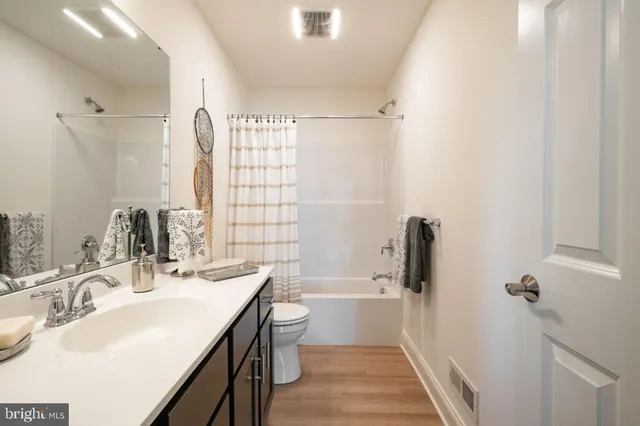 a bathroom with a double vanity sink toilet mirror and shower