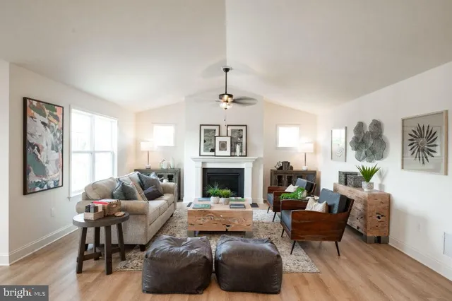 a living room with furniture a large window and a fireplace