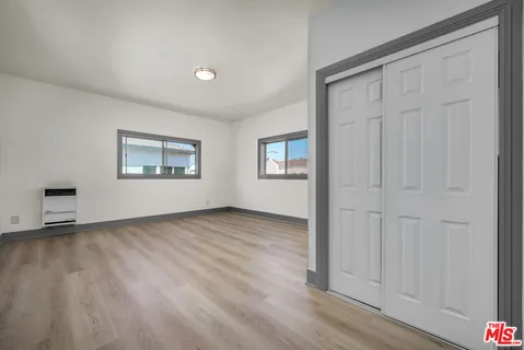 a view of an empty room with wooden floor