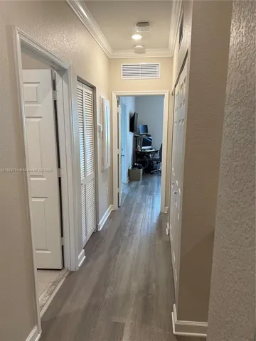 a view of a hallway with wooden floor and closet