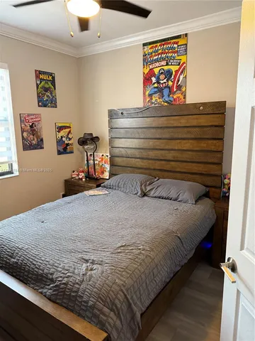 a bedroom with a bed and painting on the wall