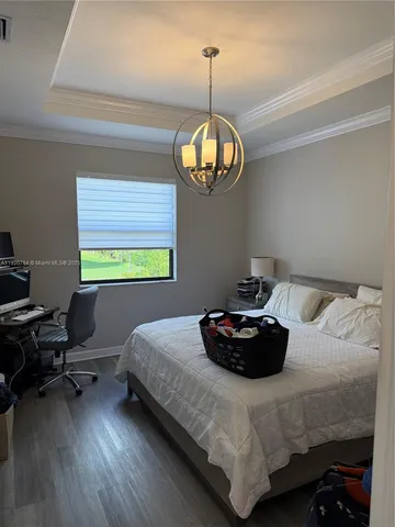a bedroom with a bed and a chandelier
