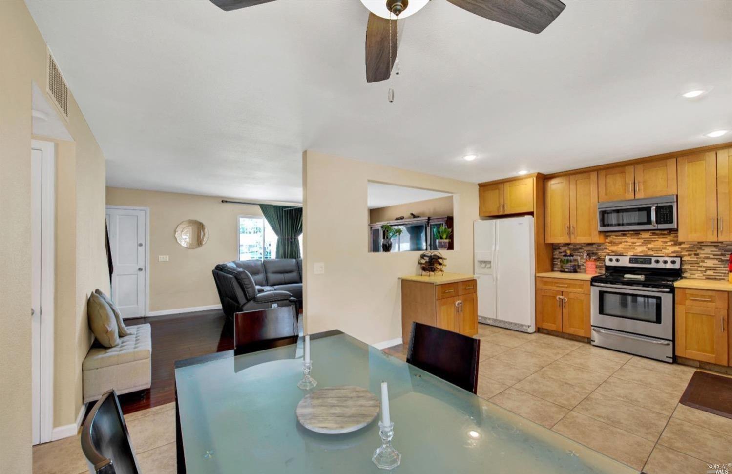 100 Arrowhead Court Vacaville, CA 95687 - Photo 16 of 40 a living room with furniture kitchen view and a wooden floor