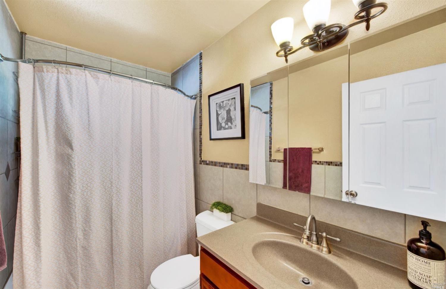 100 Arrowhead Court Vacaville, CA 95687 - Photo 18 of 40 a bathroom with a granite countertop sink and a mirror