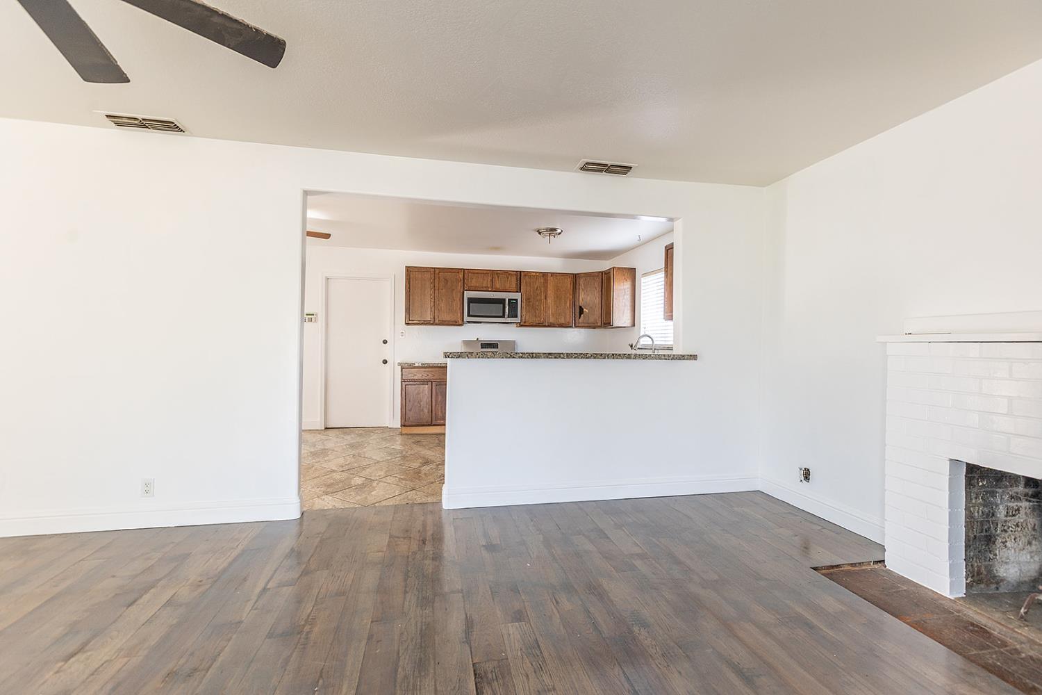 2105 Norman Way Modesto, CA 95350 - Photo 17 of 34 a view of a kitchen with wooden floor and a fireplace