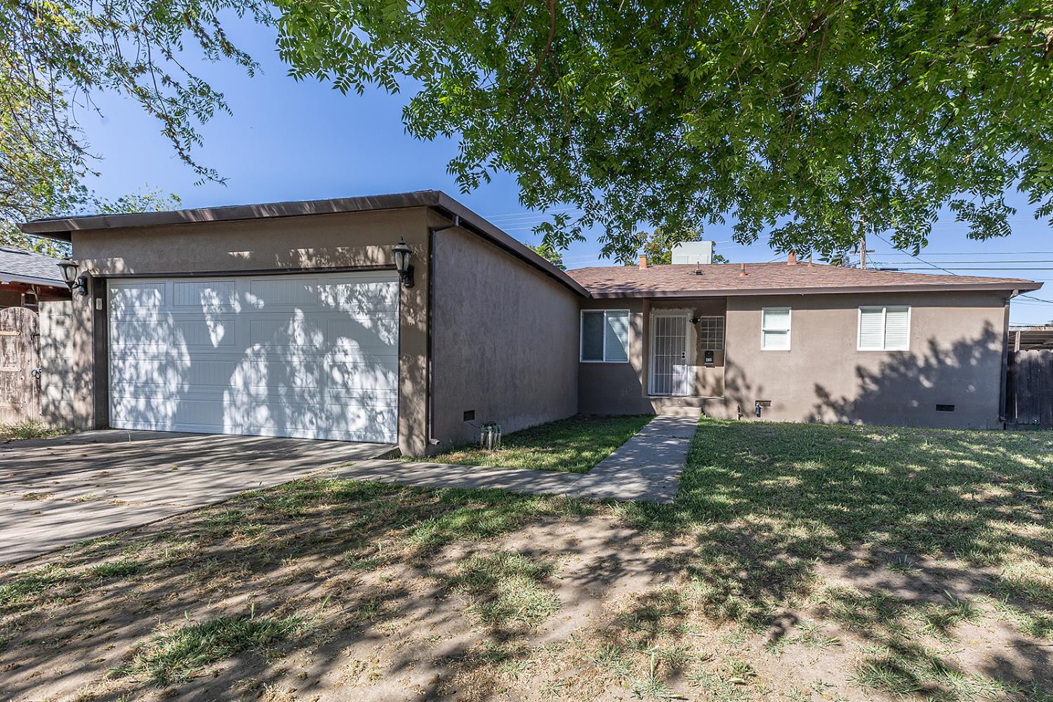2105 Norman Way Modesto, CA 95350 - Photo 4 of 34 a view of a house with a yard and a garage