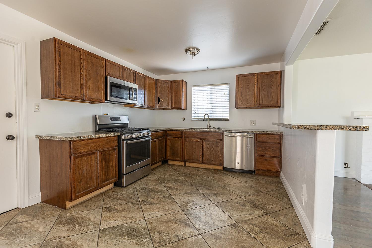 2105 Norman Way Modesto, CA 95350 - Photo 6 of 34 a kitchen with stainless steel appliances granite countertop a sink cabinets and a stove