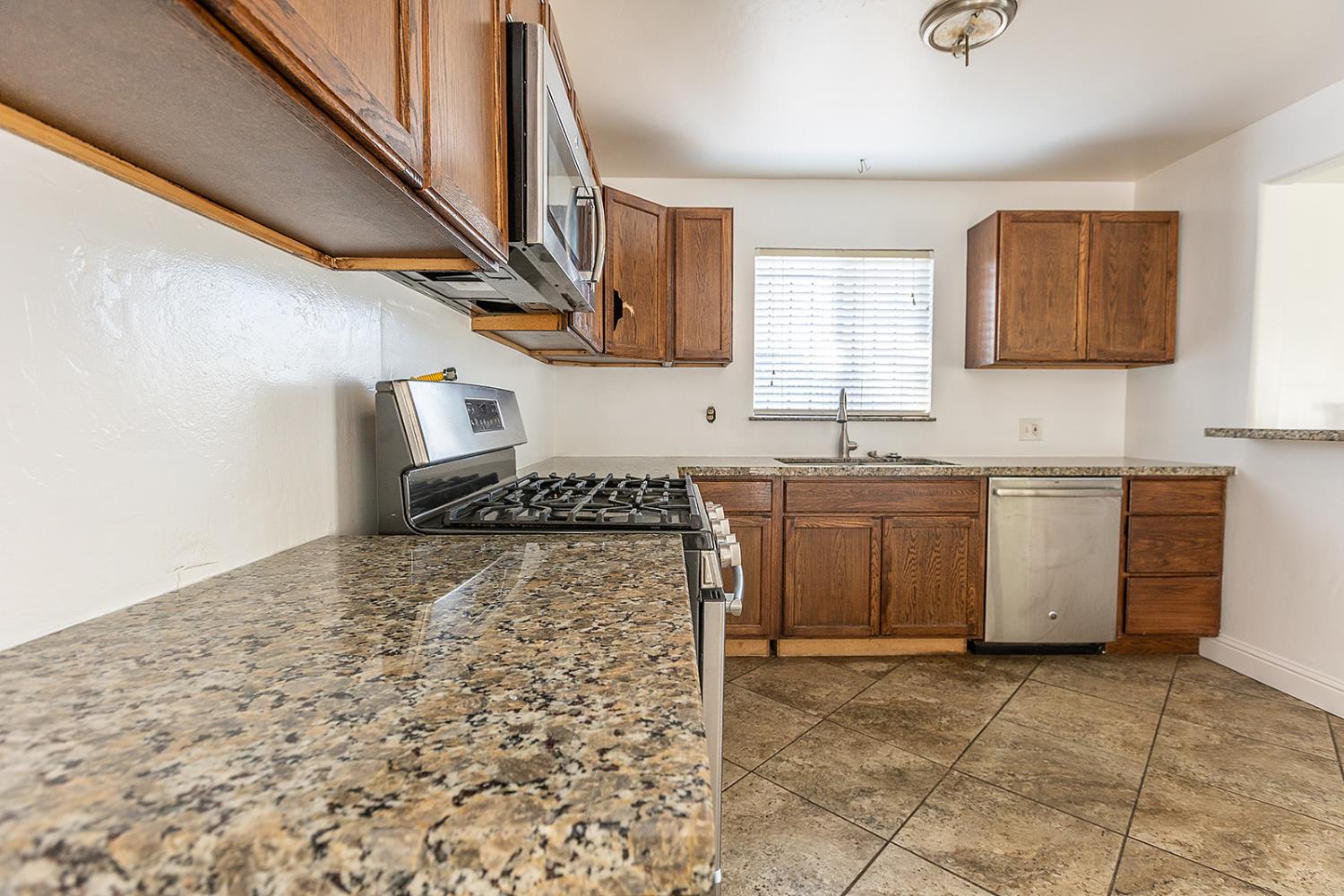2105 Norman Way Modesto, CA 95350 - Photo 7 of 34 a kitchen with a stove a sink and a refrigerator