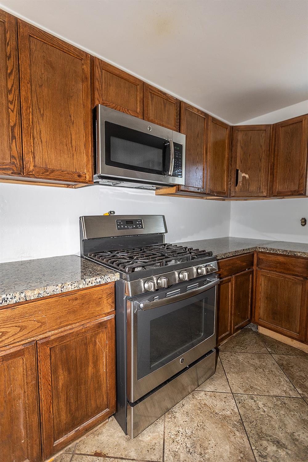 2105 Norman Way Modesto, CA 95350 - Photo 8 of 34 a kitchen with stainless steel appliances granite countertop a stove microwave and oven