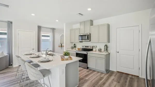 a kitchen with white cabinets and appliances