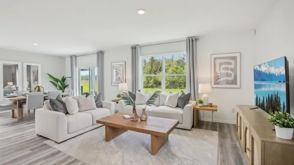 a living room with furniture potted plant and a large window