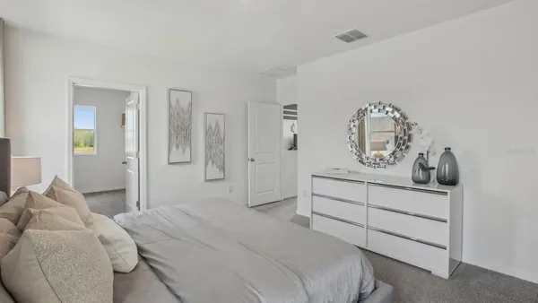 a bedroom with a bed and painting on the wall