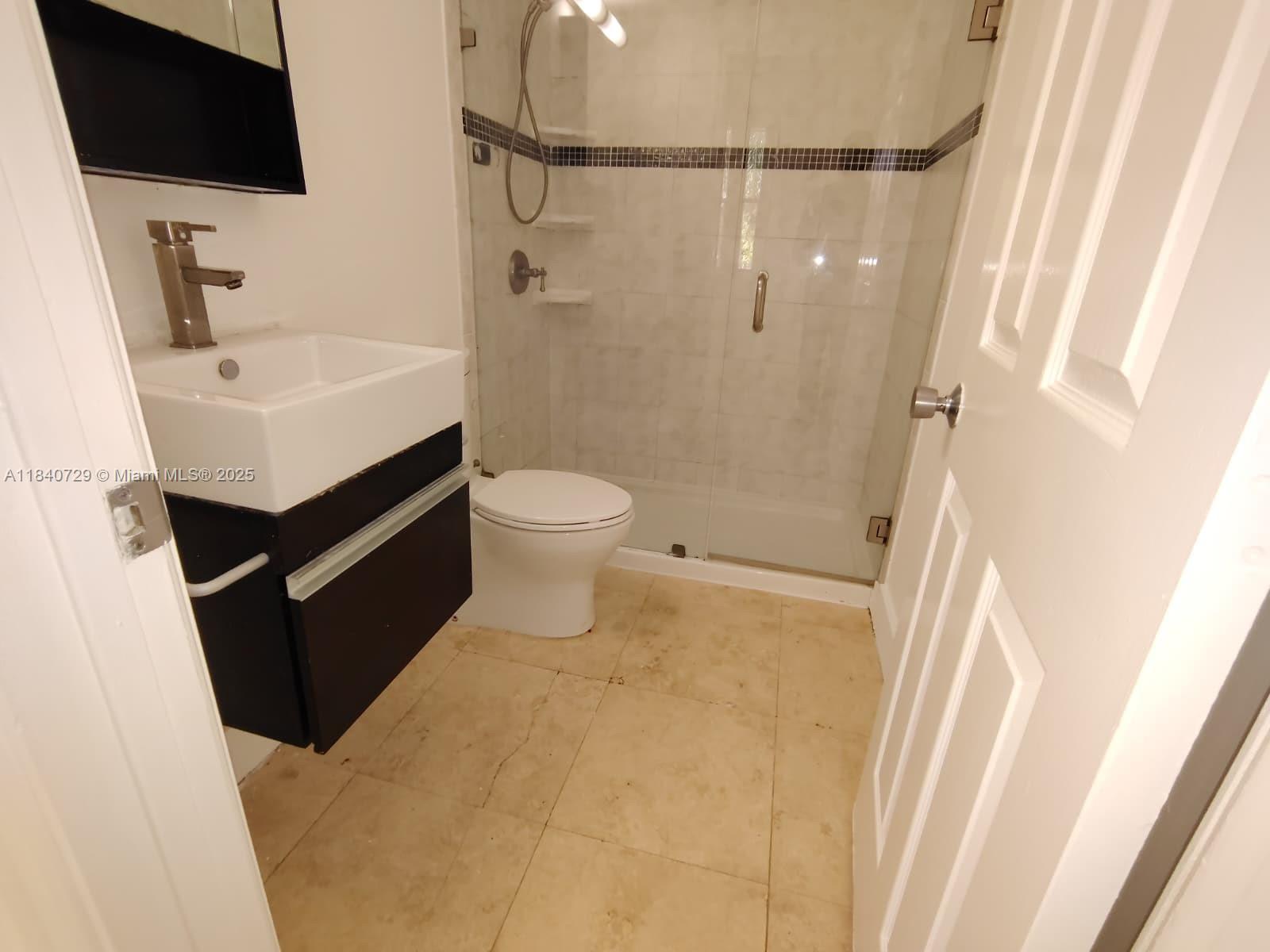 1008 Jefferson Avenue, Unit 202 Miami Beach, FL 33139 - Photo 11 of 16 a bathroom with a sink a toilet a mirror and shower