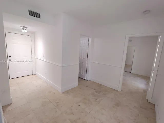 an empty room with closet and windows