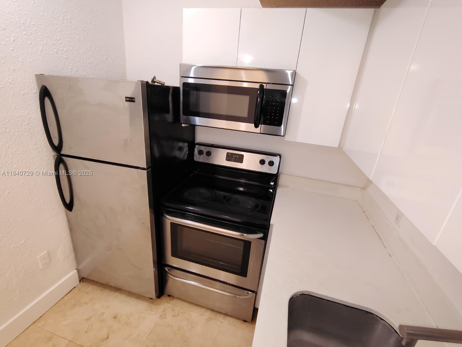 1008 Jefferson Avenue, Unit 202 Miami Beach, FL 33139 - Photo 5 of 16 a metallic refrigerator freezer sitting in a kitchen