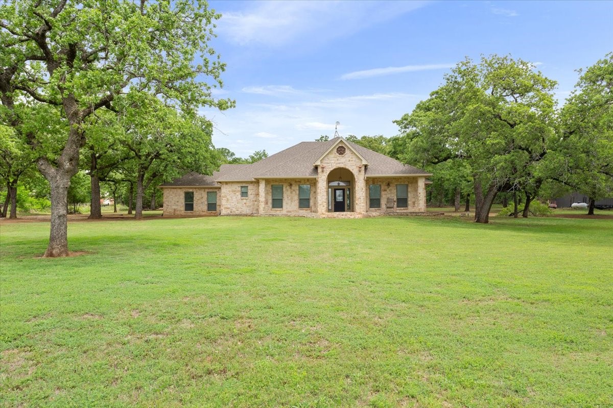 140 Oak Ridge Loop Whitney, TX 76692 - Photo 1 of 40 a front view of a house with a garden
