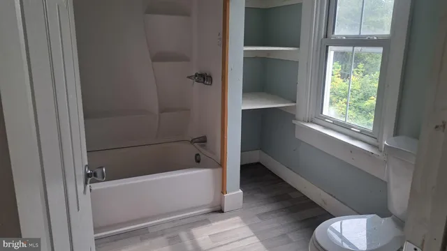 a bathroom with a tub and toilet