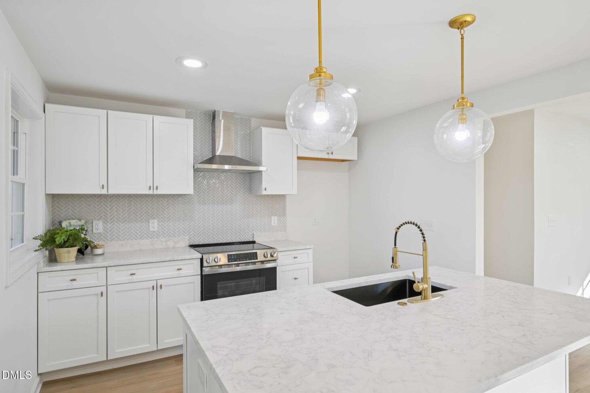 2343 Derby Drive Raleigh, NC 27610 - Photo 15 of 38 a kitchen with stainless steel appliances granite countertop a sink a stove and a wooden floors