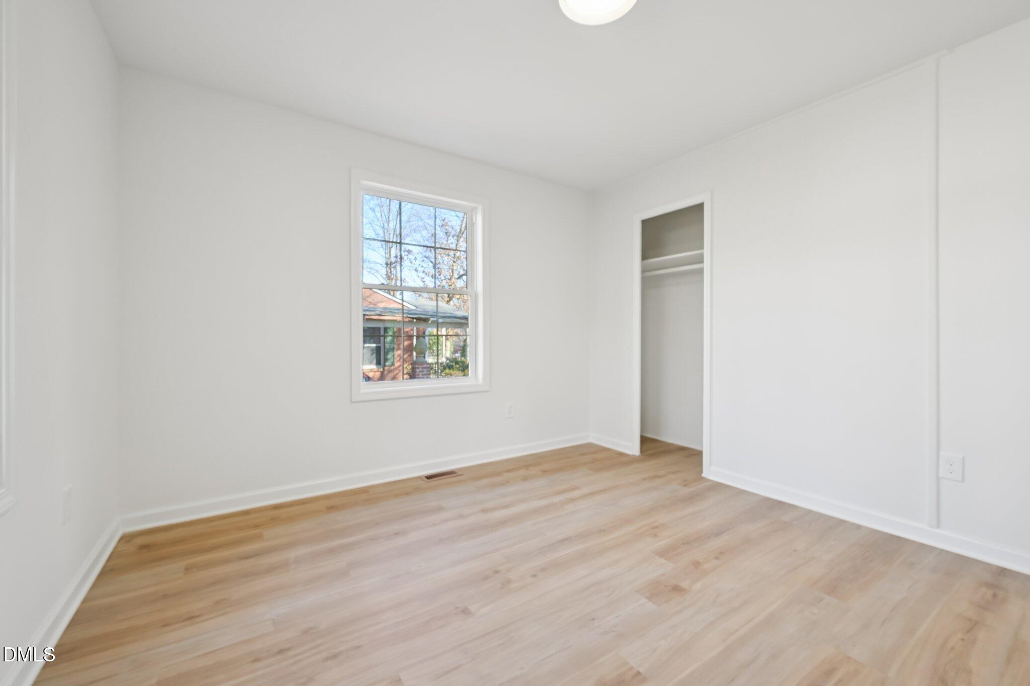 2343 Derby Drive Raleigh, NC 27610 - Photo 18 of 38 an empty room with wooden floor and windows