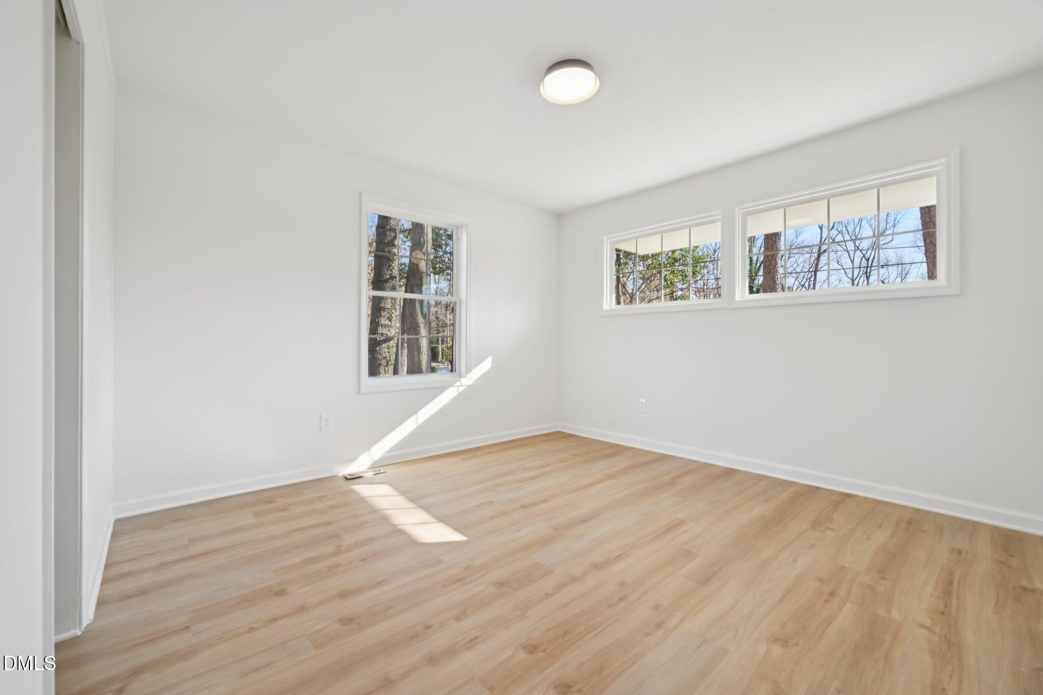 2343 Derby Drive Raleigh, NC 27610 - Photo 21 of 38 an empty room with wooden floor and windows