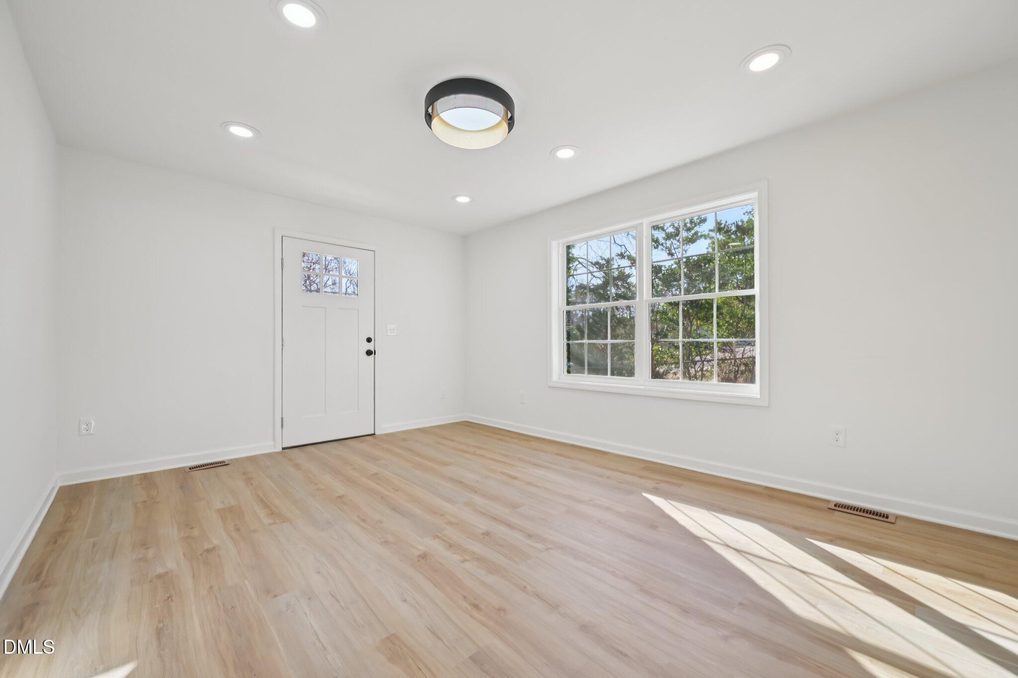 2343 Derby Drive Raleigh, NC 27610 - Photo 22 of 38 an empty room with wooden floor and windows
