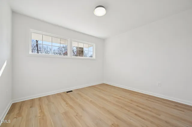 a view of empty room with wooden floor