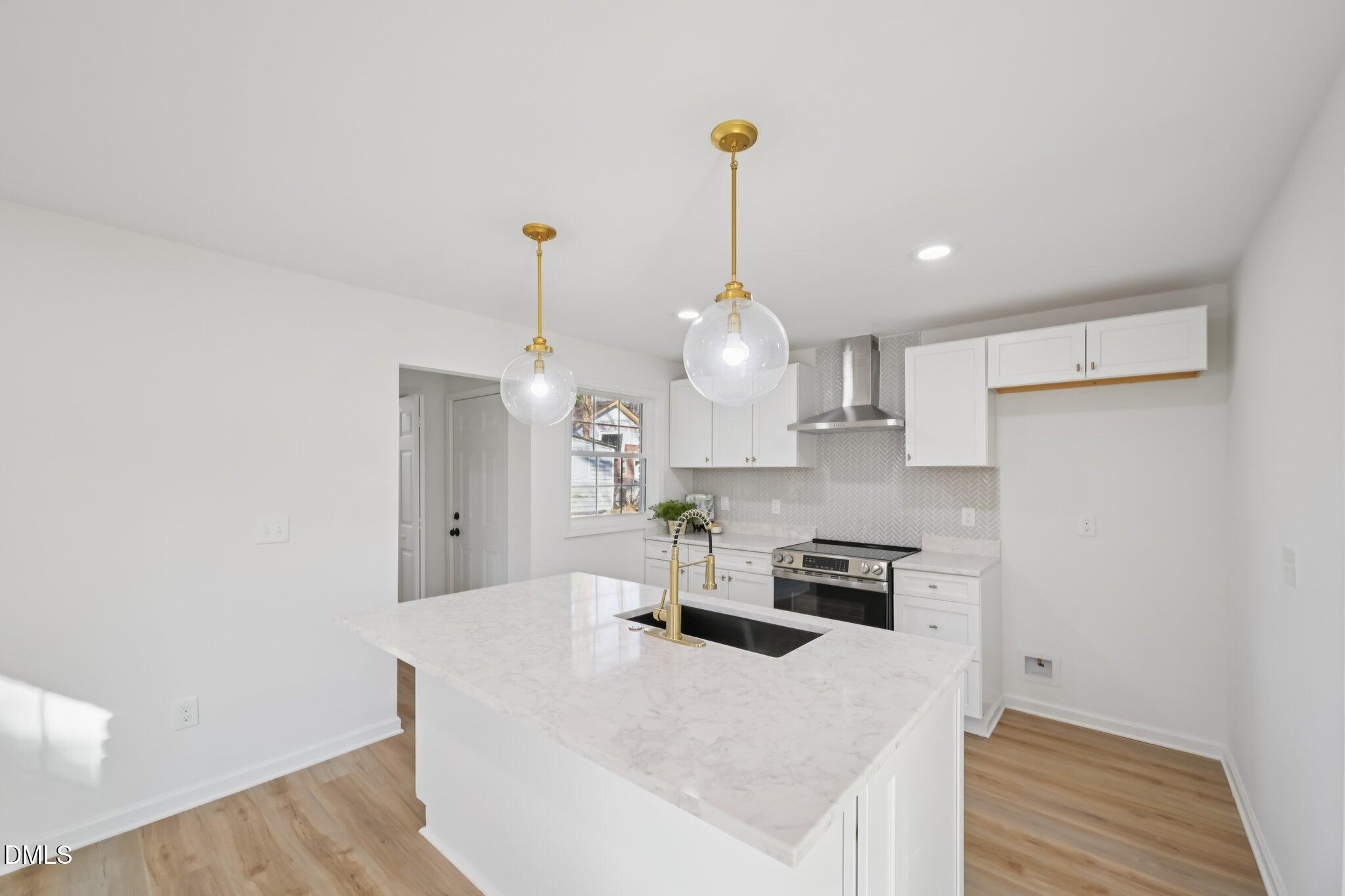 2343 Derby Drive Raleigh, NC 27610 - Photo 7 of 38 a kitchen with kitchen island a stove a sink and a refrigerator