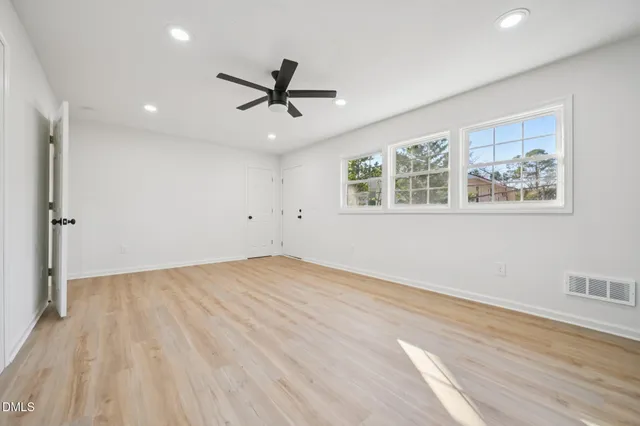 a kitchen with cabinets and wooden floor