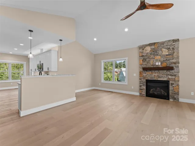 an empty room with kitchen and fireplace