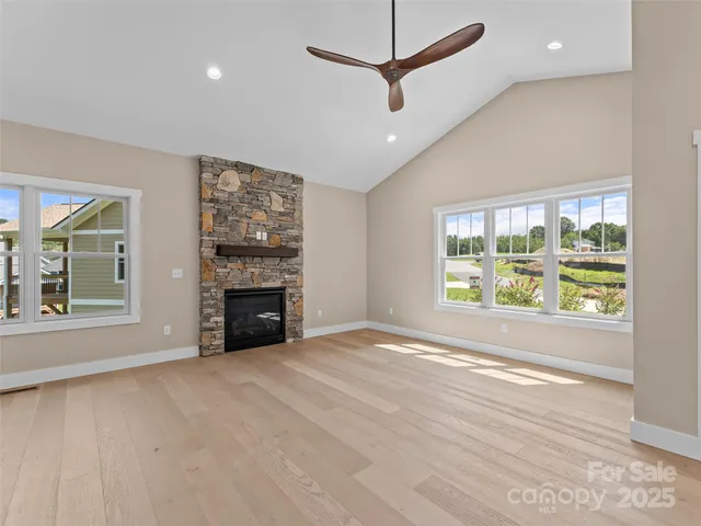 an empty room with windows and fireplace