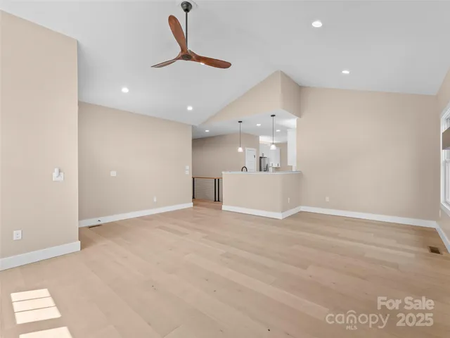 a view of a livingroom with a ceiling fan wooden floor and a ceiling fan