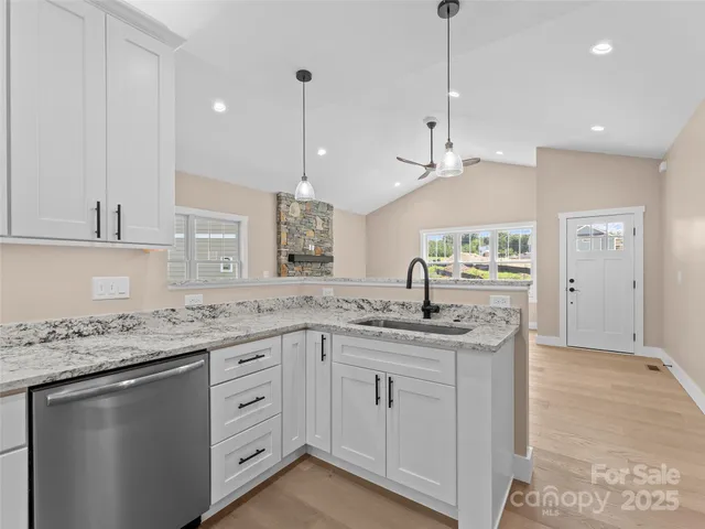 a kitchen with granite countertop kitchen island white cabinets and white appliances