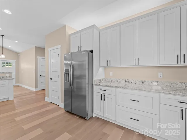 a kitchen with granite countertop white cabinets and stainless steel appliances